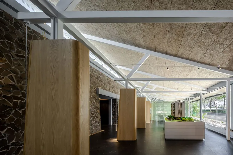 View down the lobby showing timber columns and glazed wall opening to daylit exterior