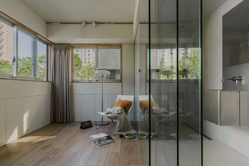 Bedroom with glass-enclosed bathroom and timber flooring beneath a white coffered ceiling