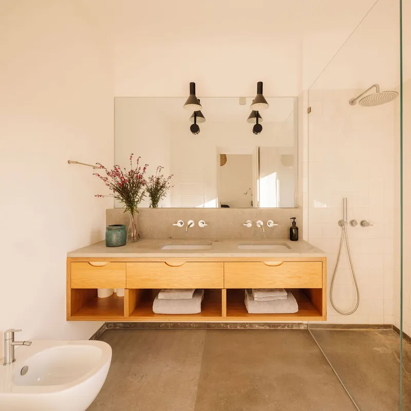 Bathroom vanity with floating timber cabinet, integrated stone countertop and wall-mounted chrome taps