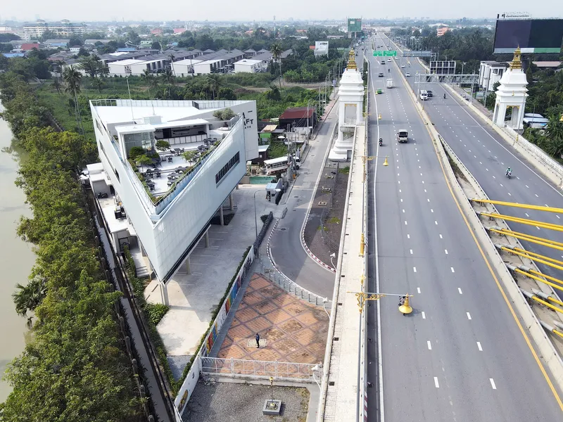 Aerial view of the elevated structure alongside a wide highway with ornamental gateway pylons
