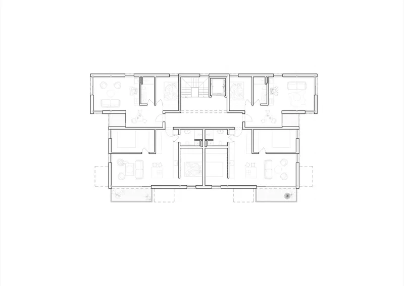 Floor plan drawing showing mirrored residential units with central stair and balconies