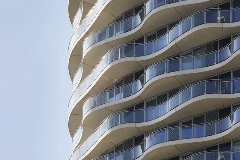 Close-up of the spiraling balconies with glass railings wrapping around the tower facade