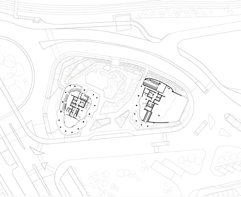 Site plan drawing showing two curvilinear tower footprints within a landscaped development parcel