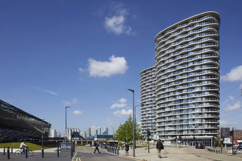 Street view of the twin residential towers with undulating balconies under a blue sky