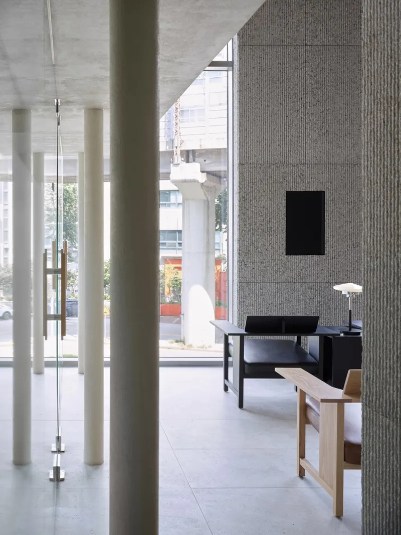 Entrance lobby with slender white columns and glass door opening to the street