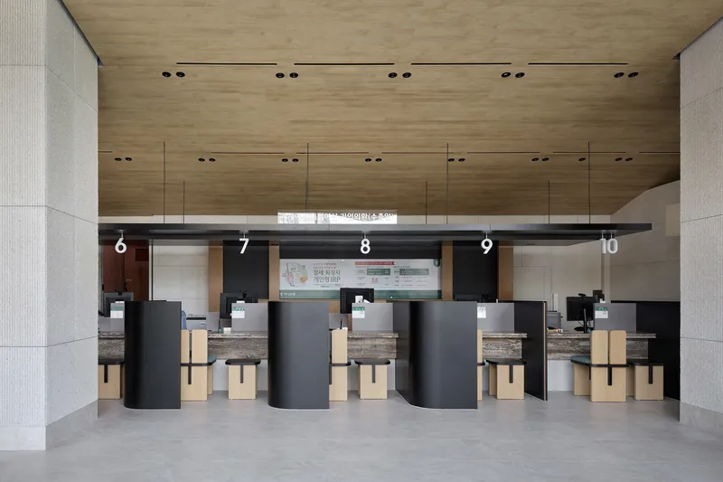 Service counter with numbered black partitions and timber ceiling beneath recessed downlights