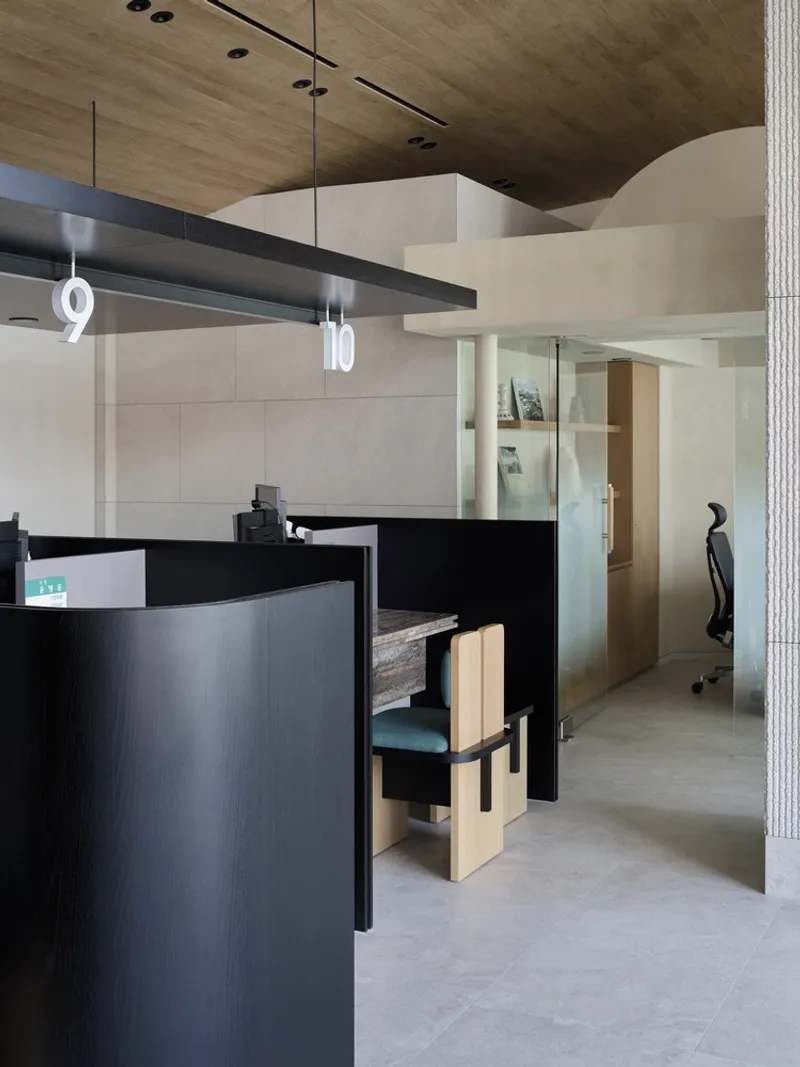 Angled view of black service desk with curved white wall and ribbed column detail
