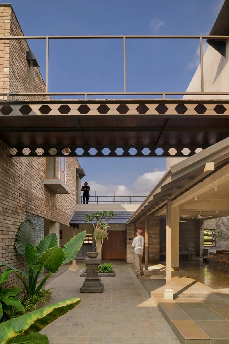 Courtyard view showing stacked bridges with patterned screens and residents on multiple levels