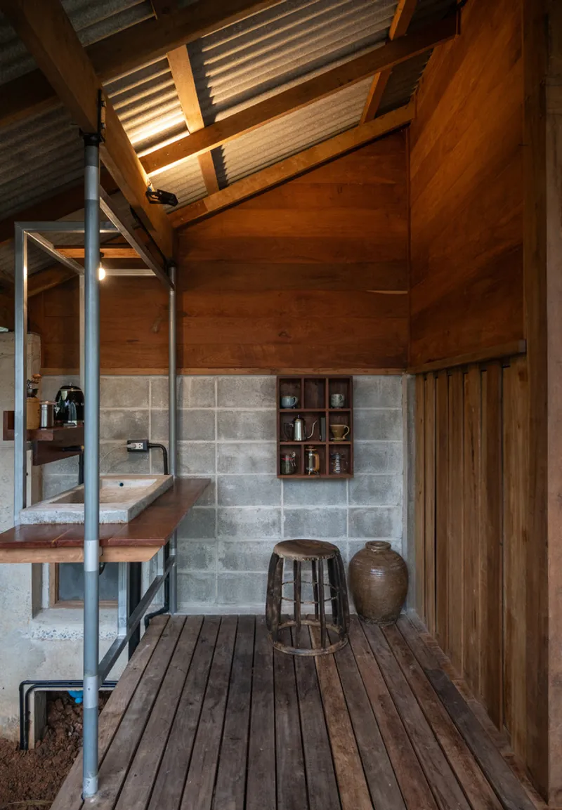 Interior kitchenette with concrete block wall, timber cabinetry and exposed wood ceiling with clerestory