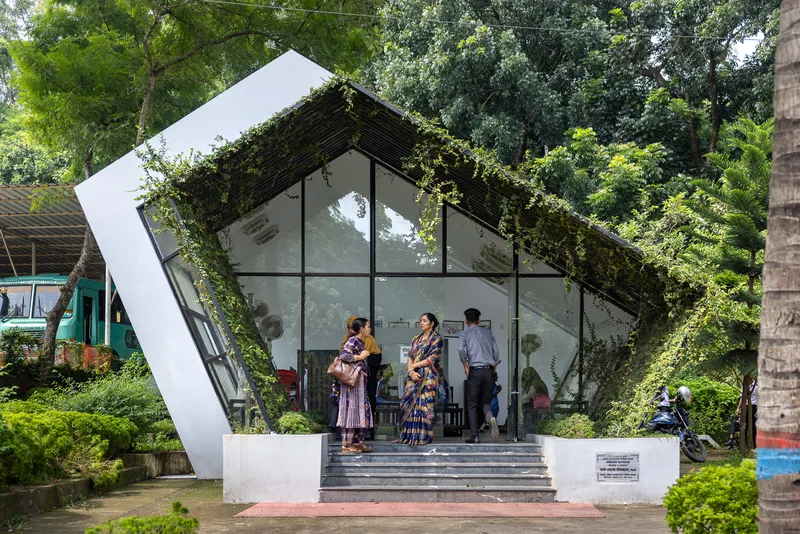 Entry facade with tilted glazed gable and climbing vines as visitors gather on the steps
