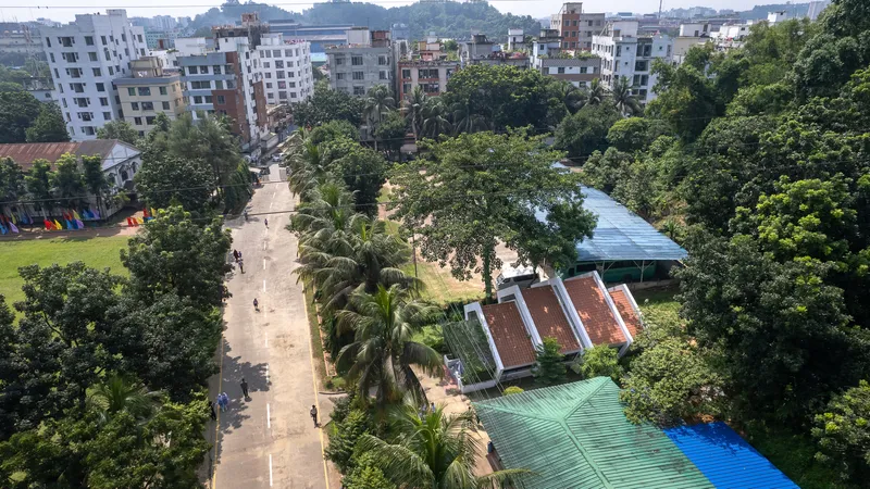 Drone view of the campus showing gabled-roof buildings among palm trees and residential blocks beyond