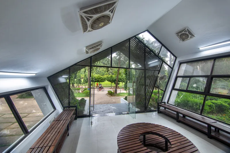 Glass door opening onto a playground visible through the angled window wall with ceiling fans above