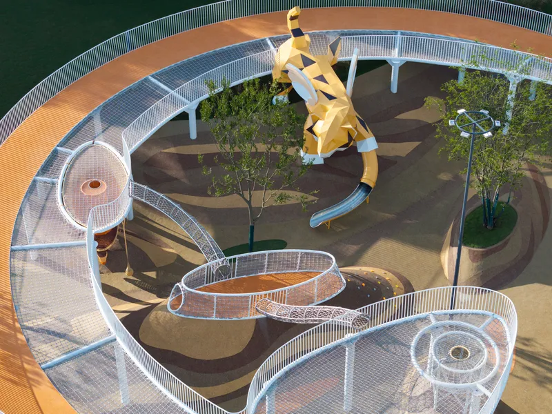 Overhead view of the spiraling mesh pathways encircling planted beds and the central yellow sculpture