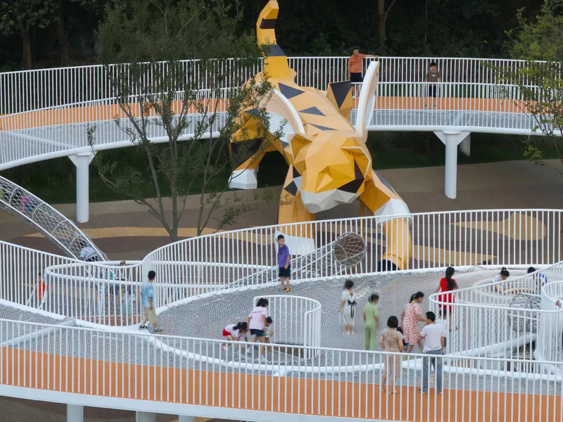 Woven metal mesh pathways and bridges framing the angular yellow sculpture with children playing