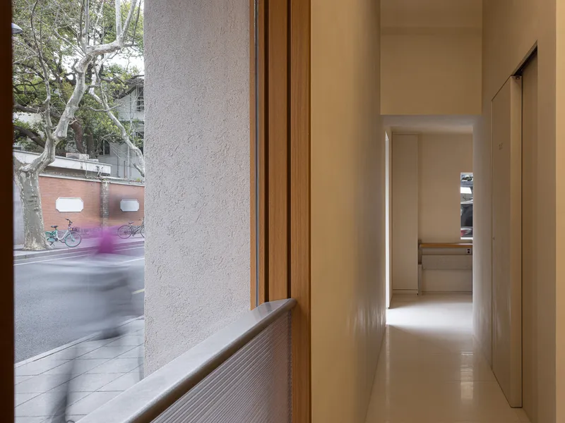 Corridor with timber window bench overlooking the street with blurred cyclist passing outside