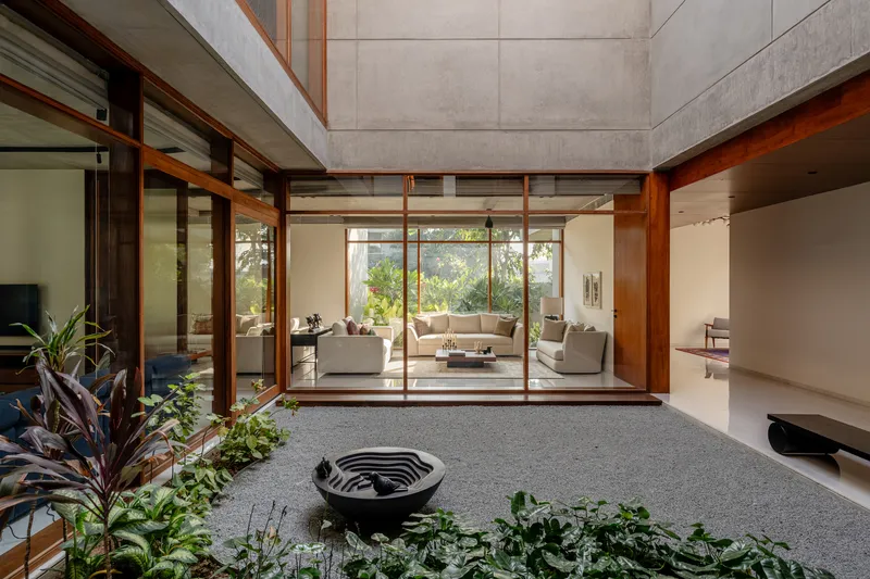 Interior courtyard with gravel floor, planted beds, and timber-framed sliding doors framing living space