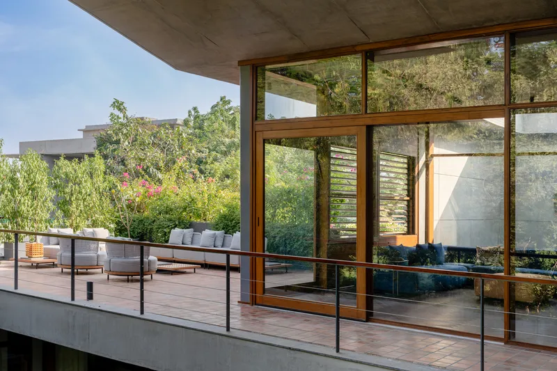 Timber-framed glazed doors opening onto a wooden deck terrace with planted garden beyond