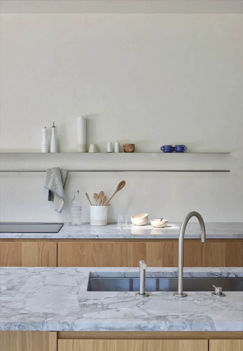 Kitchen island with white marble countertop, oak veneer base and twin floating shelves above