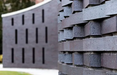 This architectural image showcases a modern brick wall with a unique pattern. The bricks are arrange