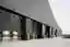 This architectural image showcases a modern industrial building with a striking black brick facade a