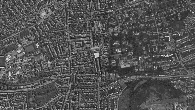 Satellite view of the urban site showing dense residential blocks and streets in the surrounding neighborhood