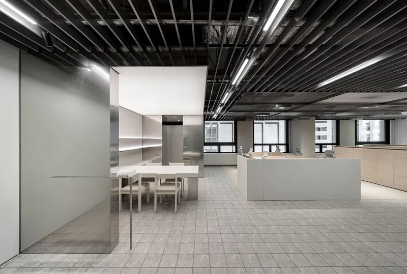 Open office floor with translucent glass meeting rooms and workstations near perimeter windows
