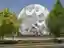 This architectural image showcases a large, white, geometric sculpture in a public space. The sculpt