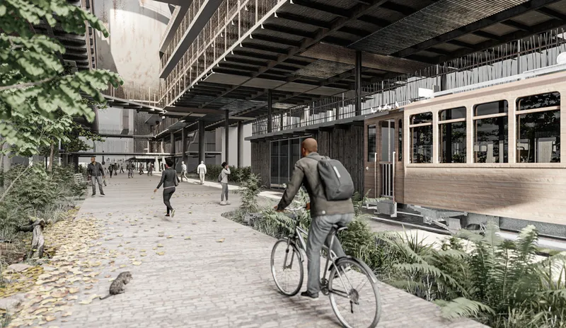 Ground-level plaza with a cyclist passing planted beds beneath cantilevered upper floors in autumn