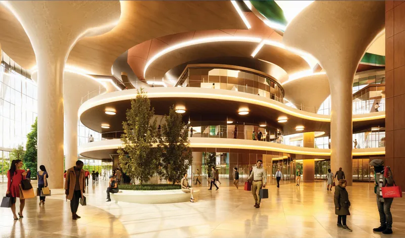 Interior atrium with spiraling balconies, organic columns, and a central tree among pedestrians