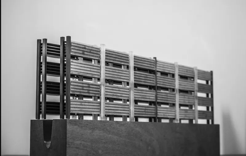 Physical model of a horizontal louvred facade with protruding structural piers mounted on a dark base