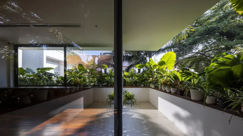 Sliding glass doors opening to a planted balcony with banana palms and dappled morning light