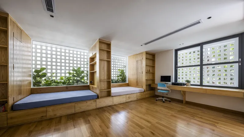 Multipurpose room with timber nooks, built-in desk and perforated block windows admitting filtered daylight