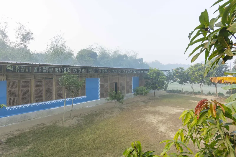 Long elevation showing bamboo panel facade with blue sections and flat metal roof in mist