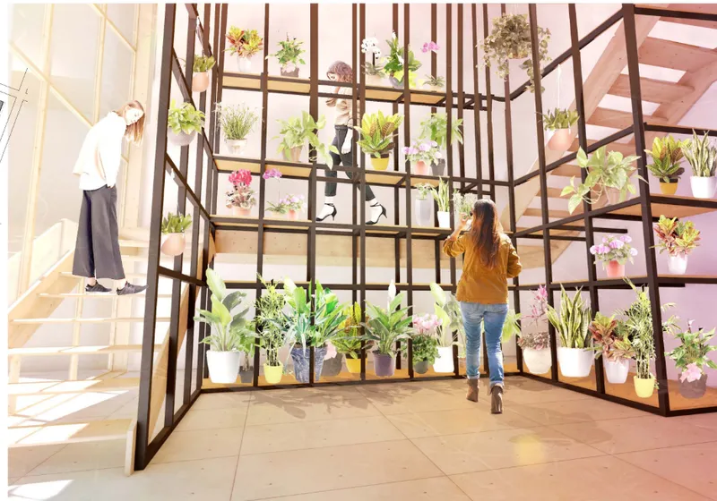 Interior view of a steel frame plant shelving structure with potted greenery and two people standing nearby