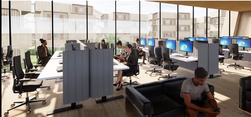 Open-plan office interior with workstations, computer screens and floor-to-ceiling windows overlooking adjacent buildings