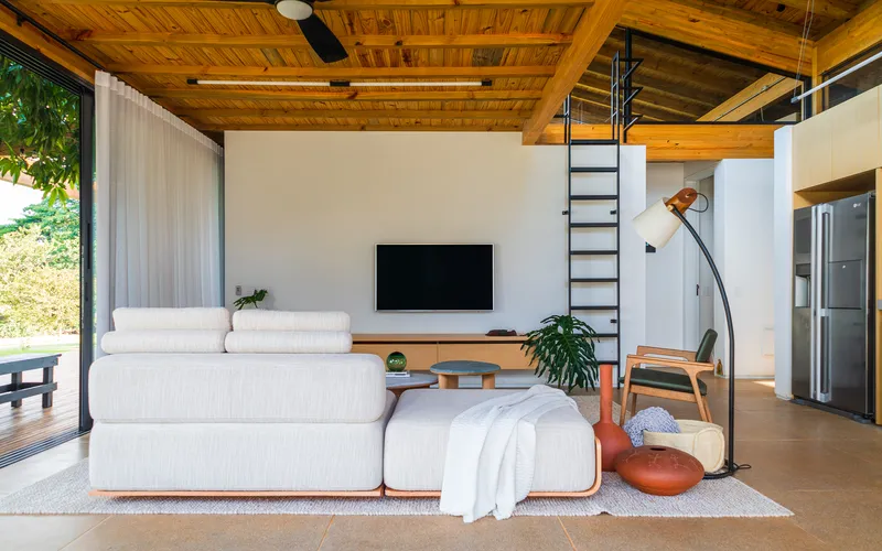 Black steel ladder ascending to mezzanine level above the living room