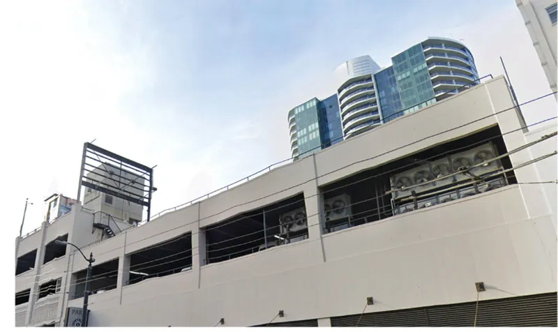 Horizontal ribbon windows in a parking structure facade with curved residential tower rising behind