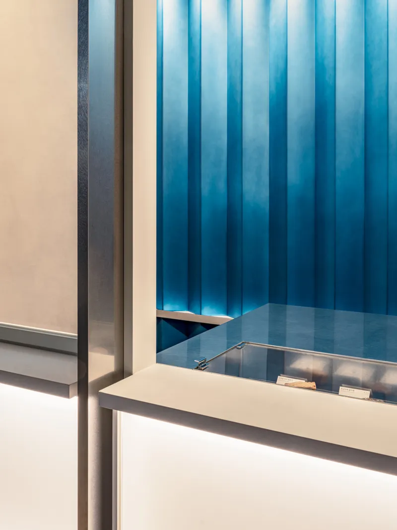 Interior corner showing blue vertical metal panel wall meeting white service counter