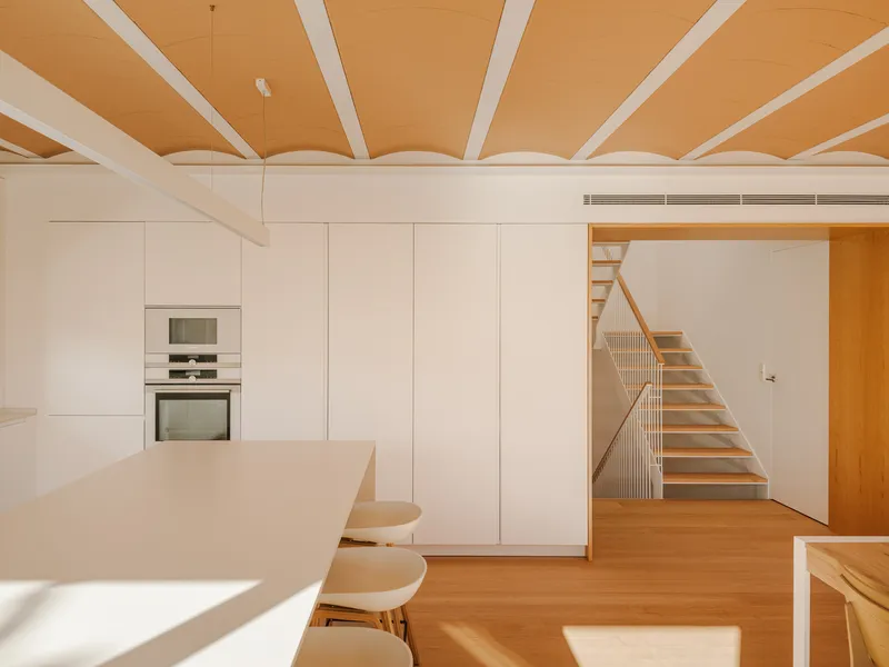 Kitchen with timber staircase visible through doorway, white cabinetry, and plywood ceiling with white beams