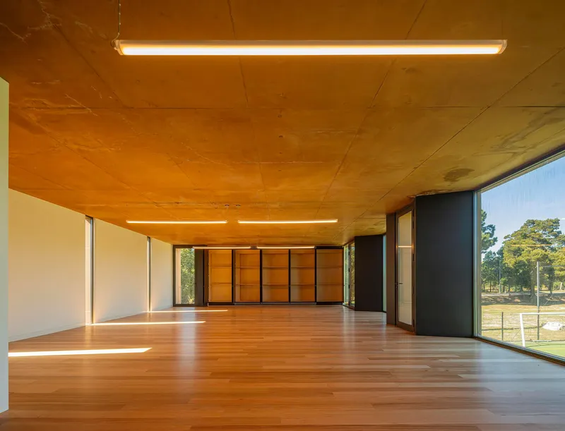 Timber floor hall with plywood ceiling showing movable partition wall and linear lighting fixtures