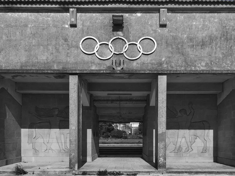 Concrete entrance canopy with relief carvings and weathered surfaces in black and white