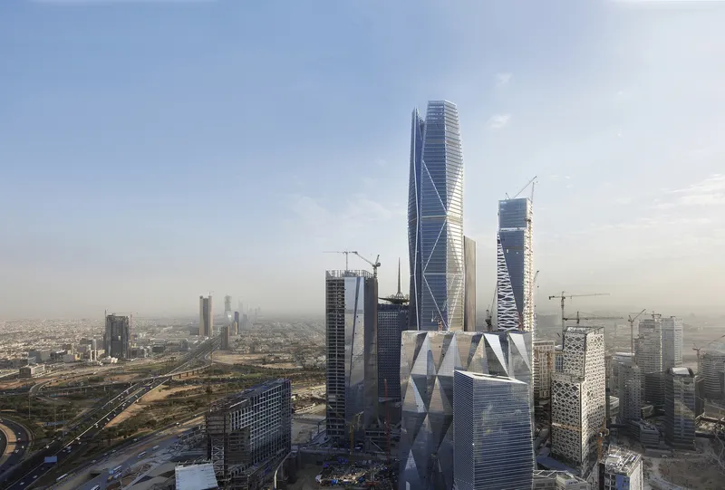 Aerial view of a cluster of high-rise towers with diagonal bracing and glass facades at dusk