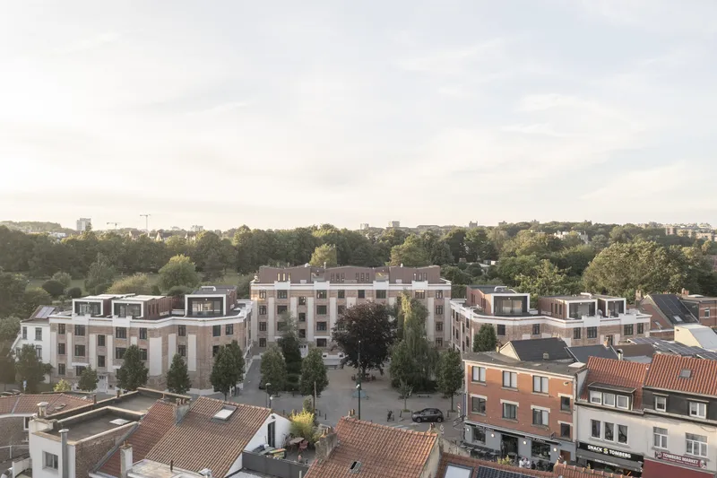 Aerial view of the symmetrical courtyard complex with rooftop terraces at dusk