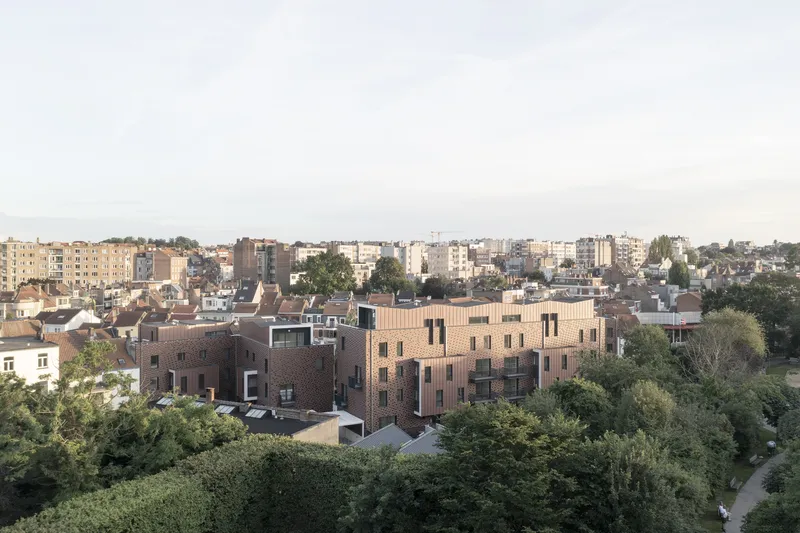 Elevated view of the brick residential block nestled among surrounding trees and rooftops