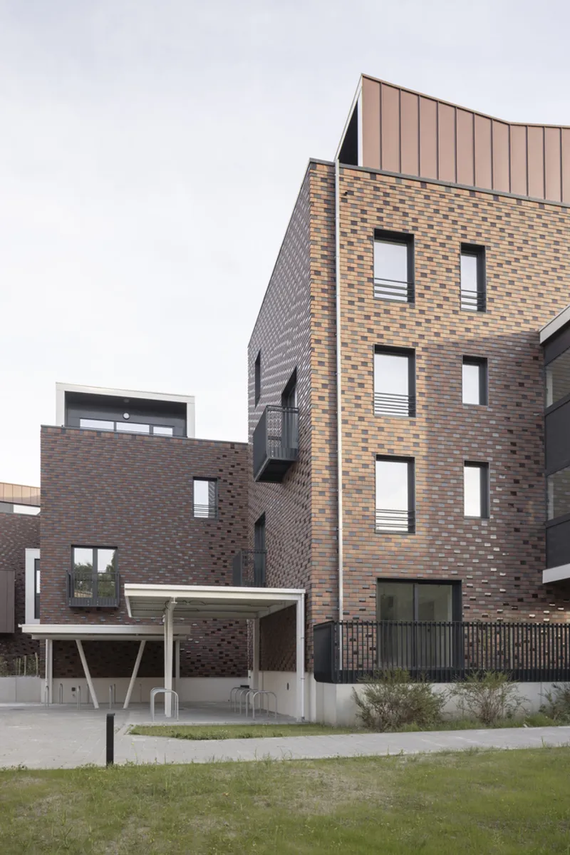 Multicolored brick tower with recessed balconies and a metal standing seam roof pavilion