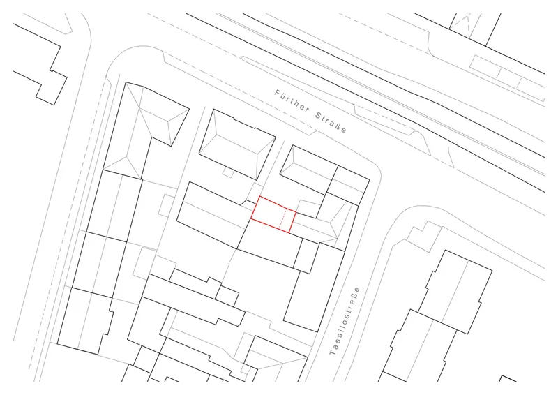 Site plan drawing showing a rectangular building footprint highlighted in red among surrounding blocks