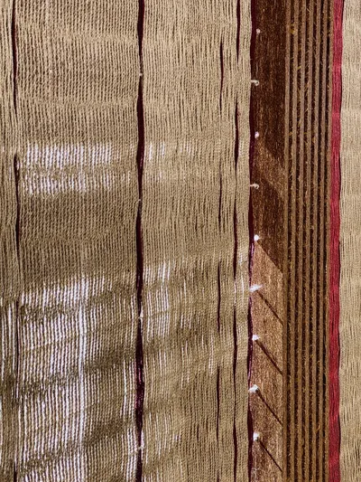 The image showcases a close-up of a woven textile with vertical lines and a rich, earthy color palet