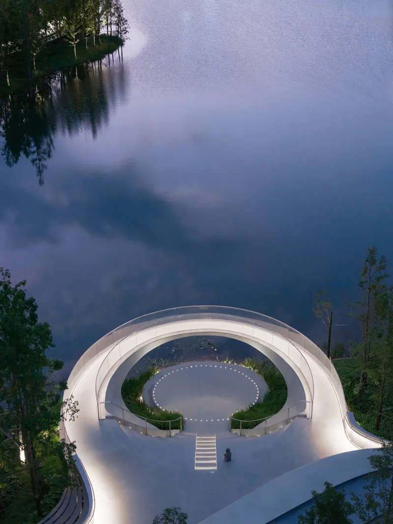 Aerial view of the circular white concrete roof canopy enclosing a central courtyard at dusk