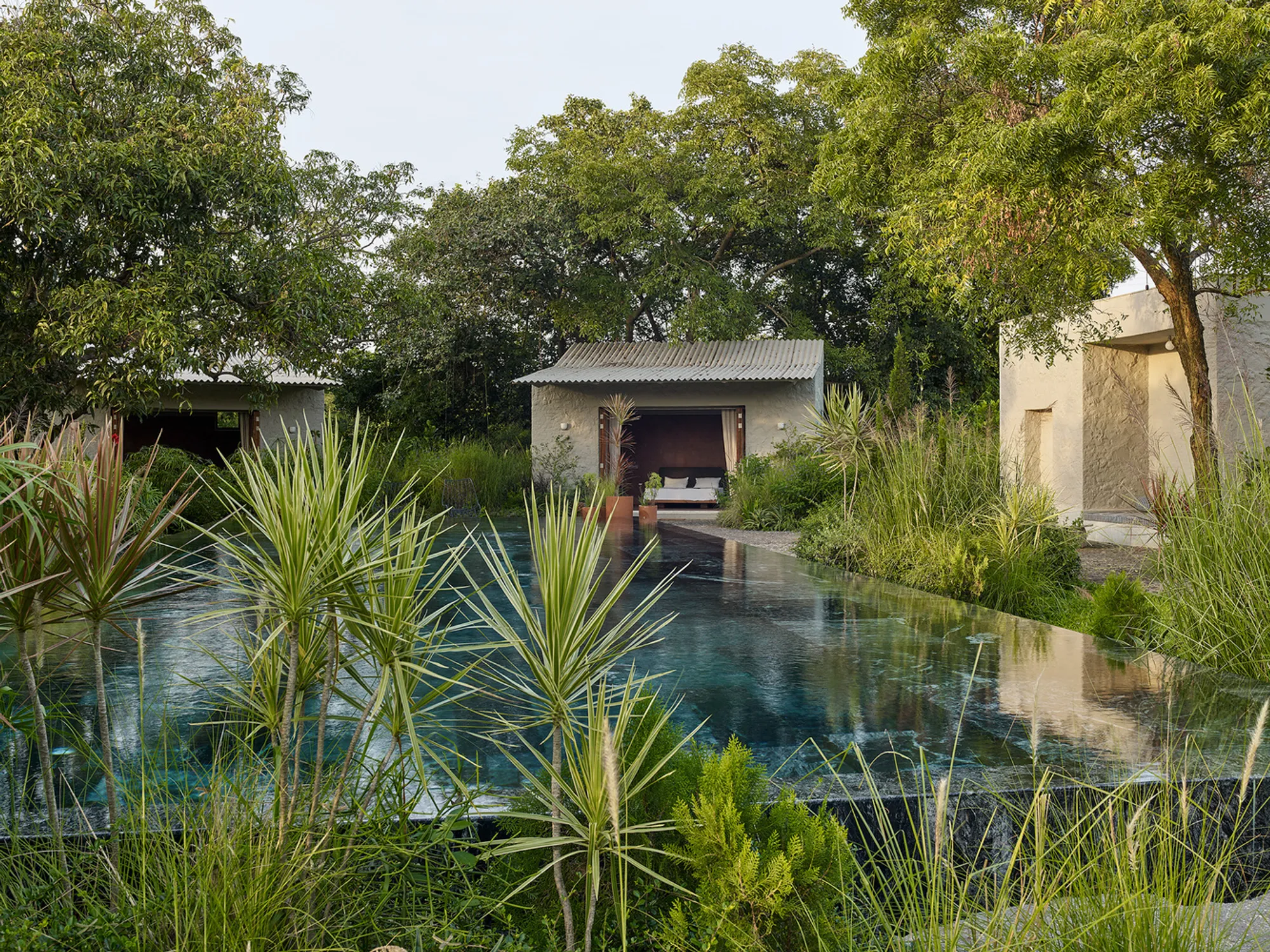 Case Design Scatters a Brick-and-Basalt Villa Beneath Mango Trees in Rural Alibaug