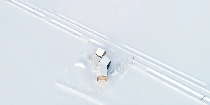 Aerial view of the three-volume compound amid tire tracks in deep snow